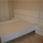  Мебель для спальни Большая кровать с глянцевыми панелями.